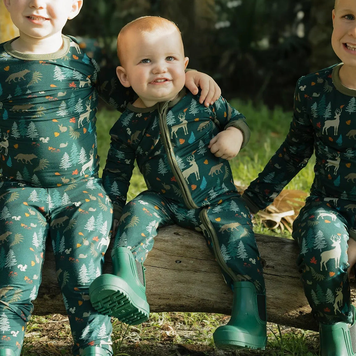 baby wearing midnight forest print zippie on greenery background.