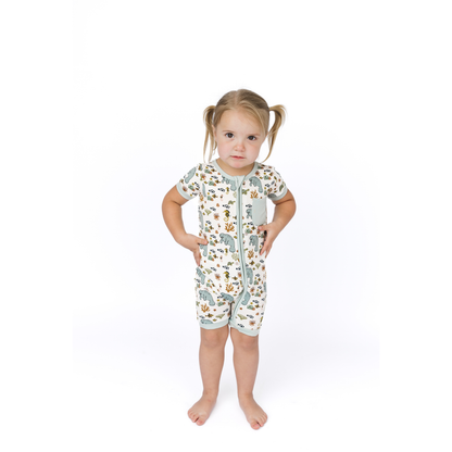 Child wearing a patterned onesie on a white background