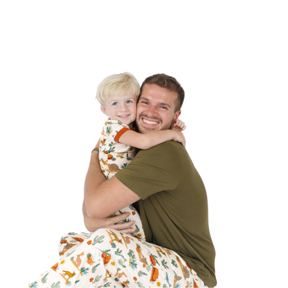 Man hugging a child wearing a patterned outfit on a white background