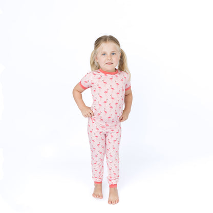 girl standing in pink flamingo pajamas.