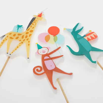 Colorful animal-themed cake toppers on sticks with a giraffe, monkey, and dinosaur design.
