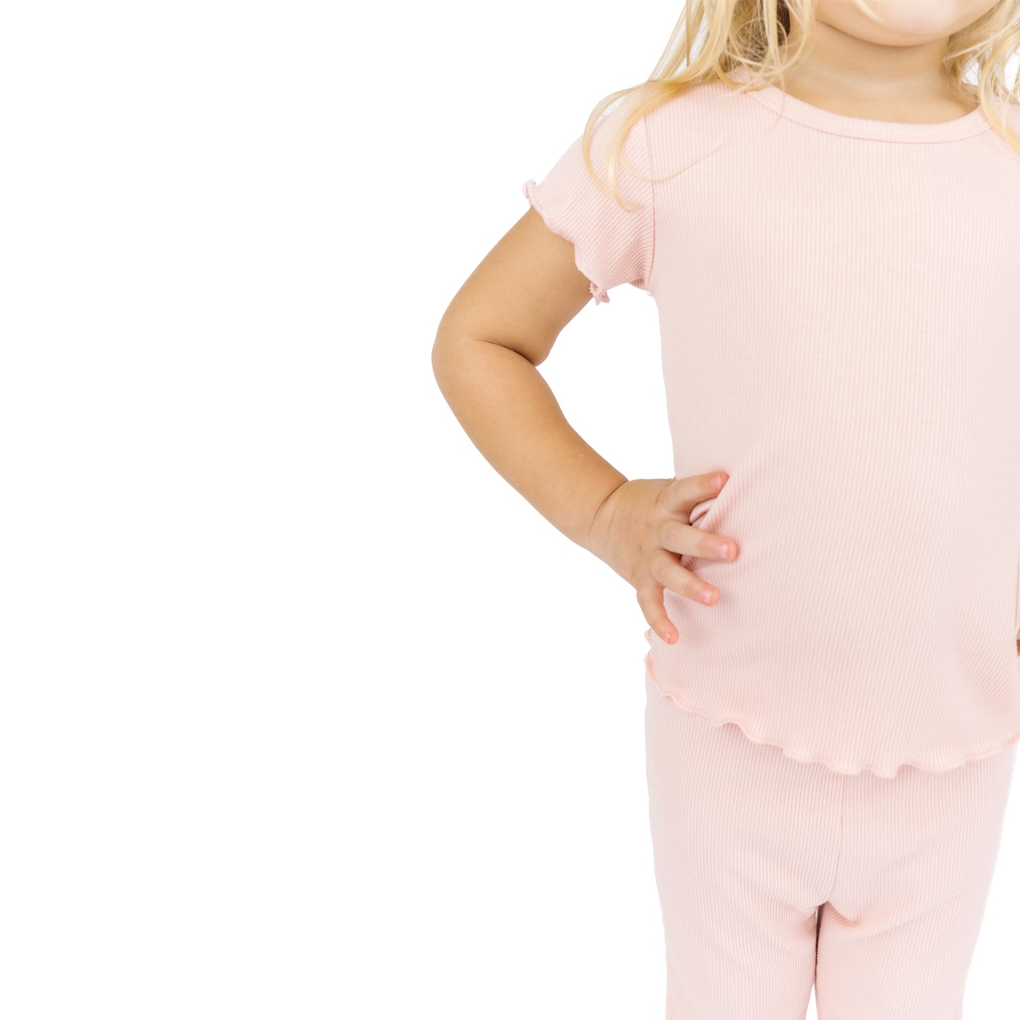 Child wearing a pink outfit with ruffled sleeves and pants on a white background