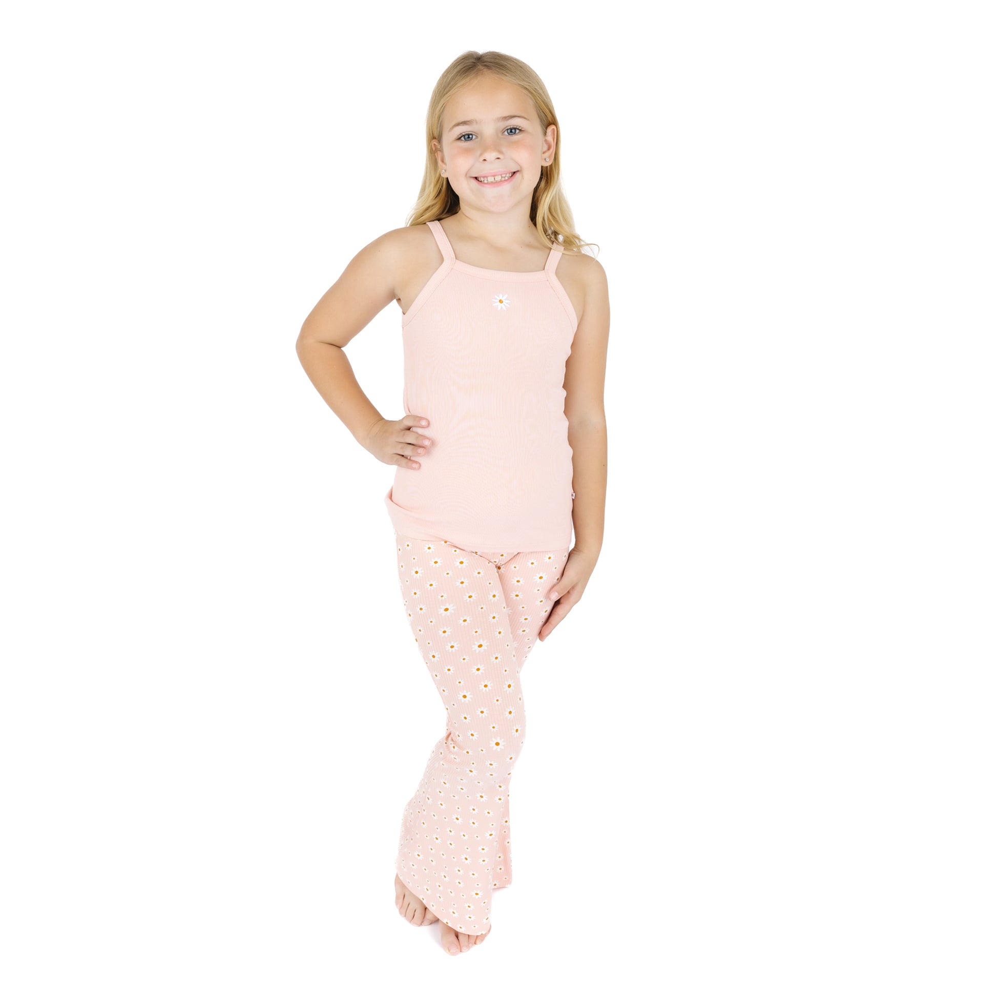 Young girl wearing a pink sleeveless top and polka dot pants on a white background