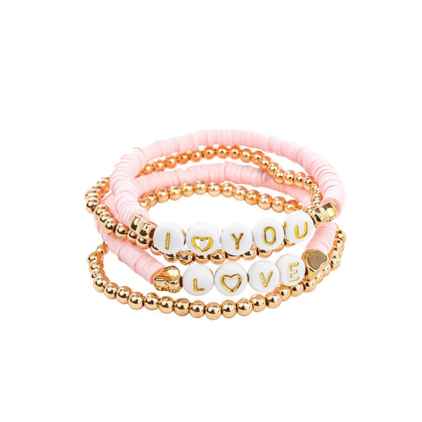 Set of four stacking pink and gold beaded bracelets with letter beads spelling out "I love you" and "Love" from Great Pretenders