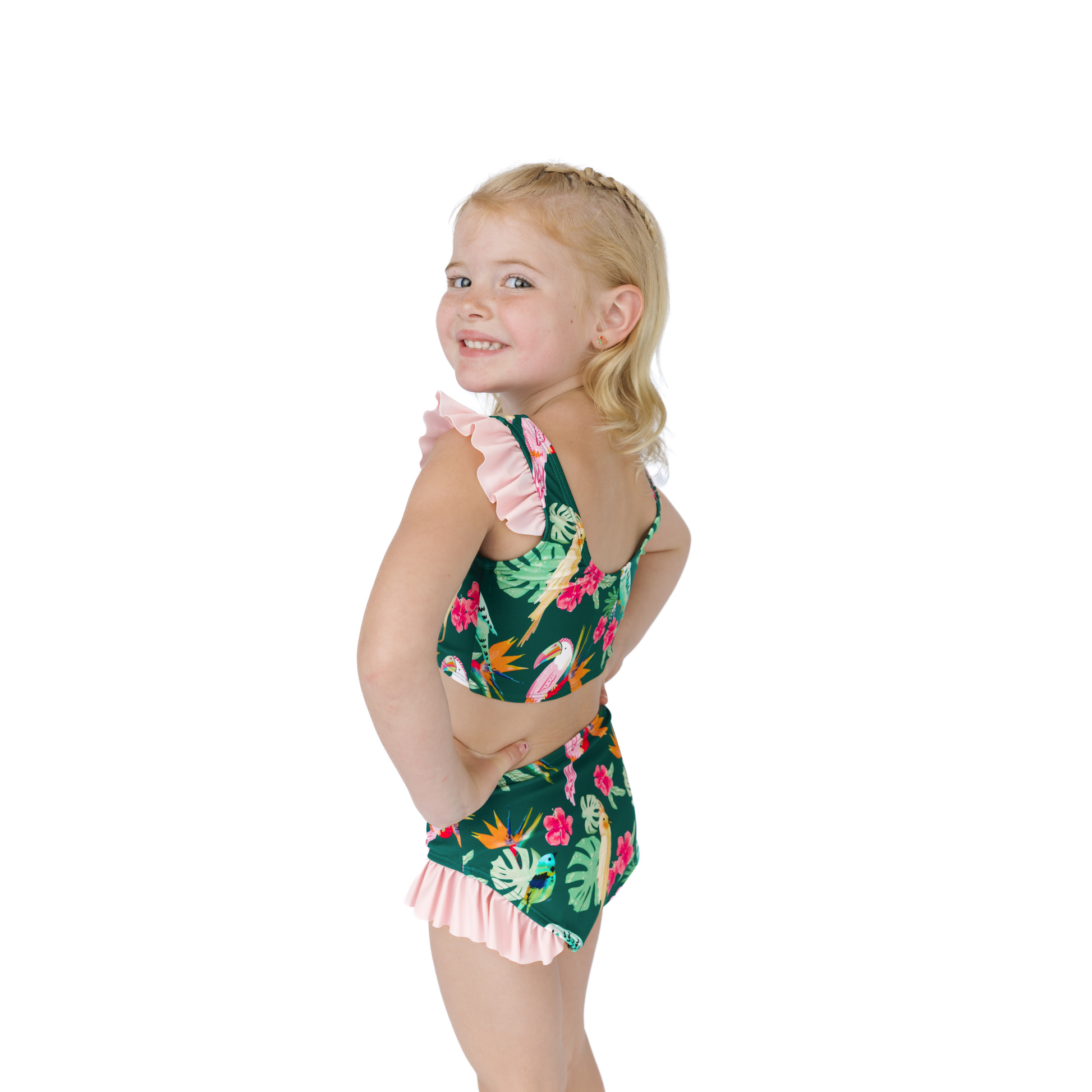 Young girl wearing a tropical print swimsuit on a white background