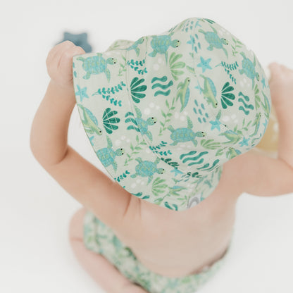 A beach-ready bucket hat from the Save the Sea Turtle collection, designed for comfort and sun protection for little ones. Featuring an ocean-inspired print with adorable sea turtles and marine elements, this hat is perfect for sunny adventures.