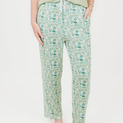 Woman wearing our Relaxed Long Pants from our Save the Sea Turtle Collection. Featuring\a serene ocean-inspired print with sea turtles and marine life, these ultra-soft bamboo pieces are breathable, moisture-wicking, and eco-friendly. Perfect for lounging or sleeping in sustainable style.