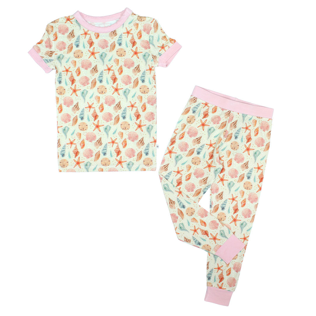 Our 2-piece Sandy Seashell bamboo pajama for toddler flat lay in a white background.