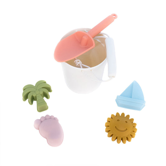 the silicone white bucket beach toy set. this comes with a pink shovel, green palm tree, blue sailboat, purple footprint, and a yellow sun