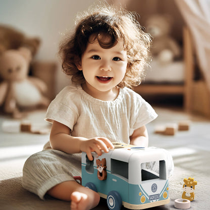 a little girl playing with a wooden toy shape sorting van sitting on a rug in a bedroom with toys and a bed in the background