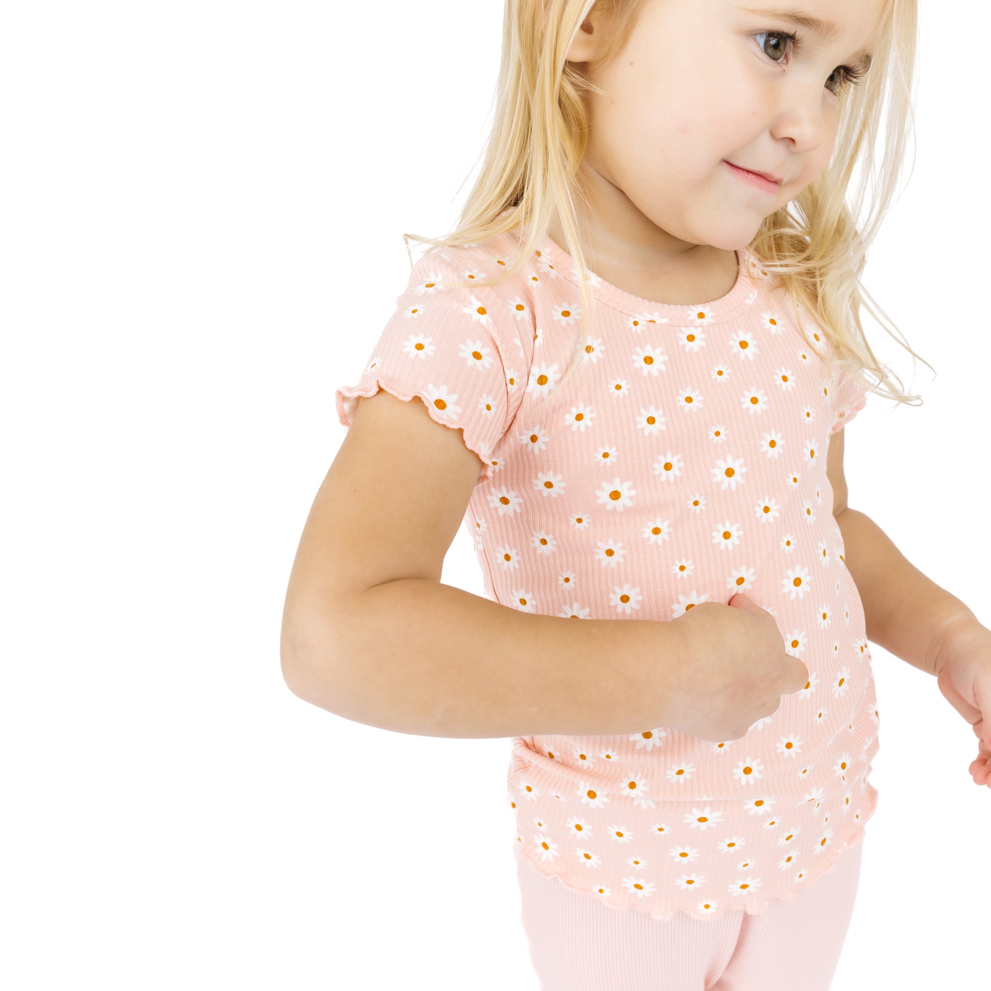 Young girl wearing a pink outfit with a subtle pattern on a white background