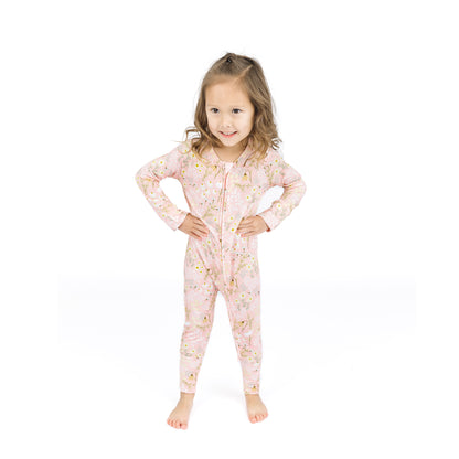 Young girl wearing a pink floral onesie on a white background