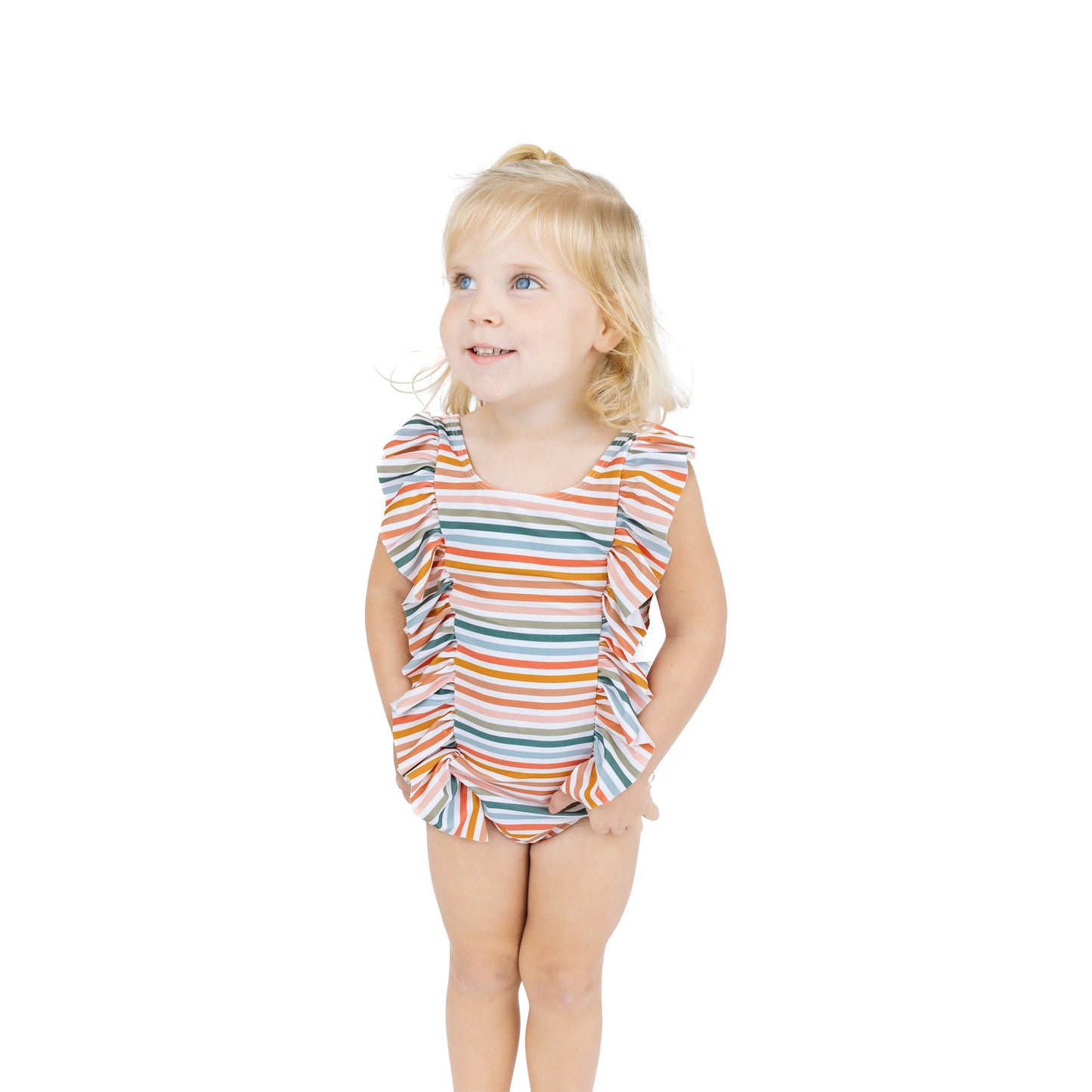Young girl wearing a colorful striped swimsuit on a white background