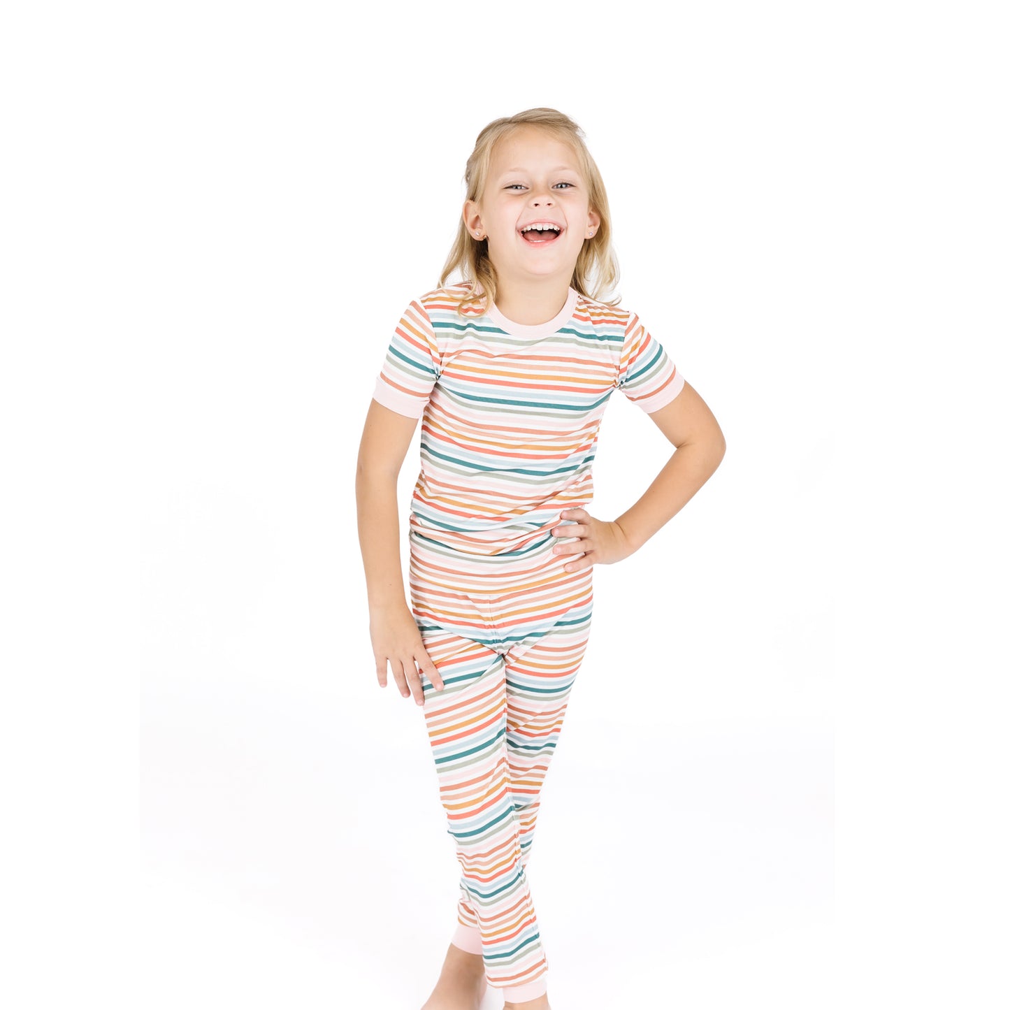 Child wearing a colorful striped pajama set on a white background