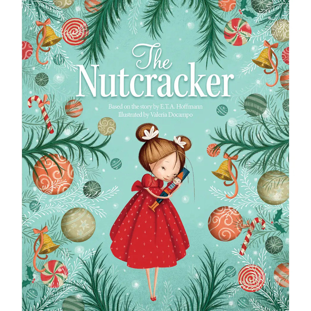 A little girl in a red dress hugging a nutcracker with Christmas tree branches and ornaments surrounding her