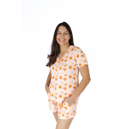 Woman wearing a an orange pajama set on a white background