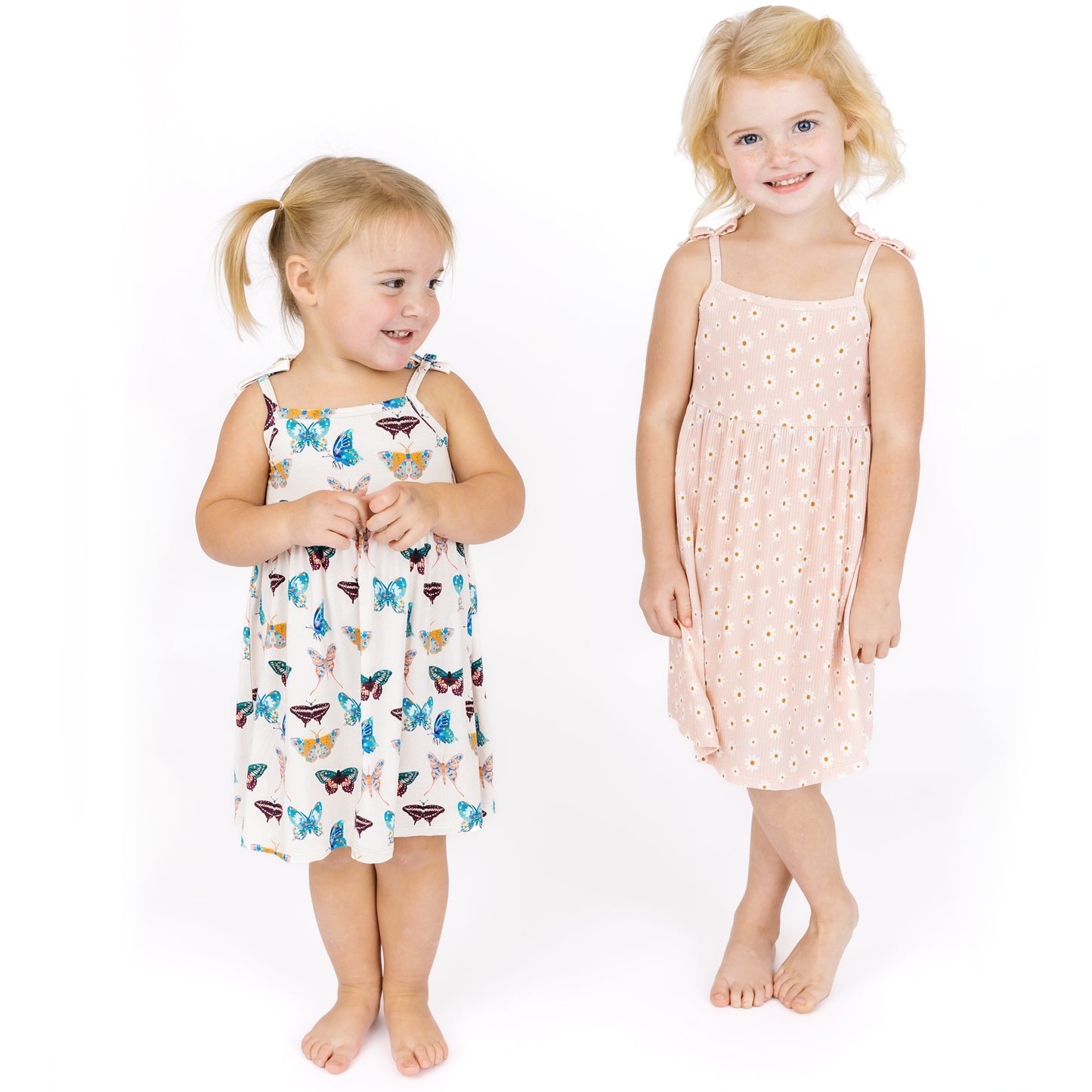 Two young girls wearing sundress on a white background