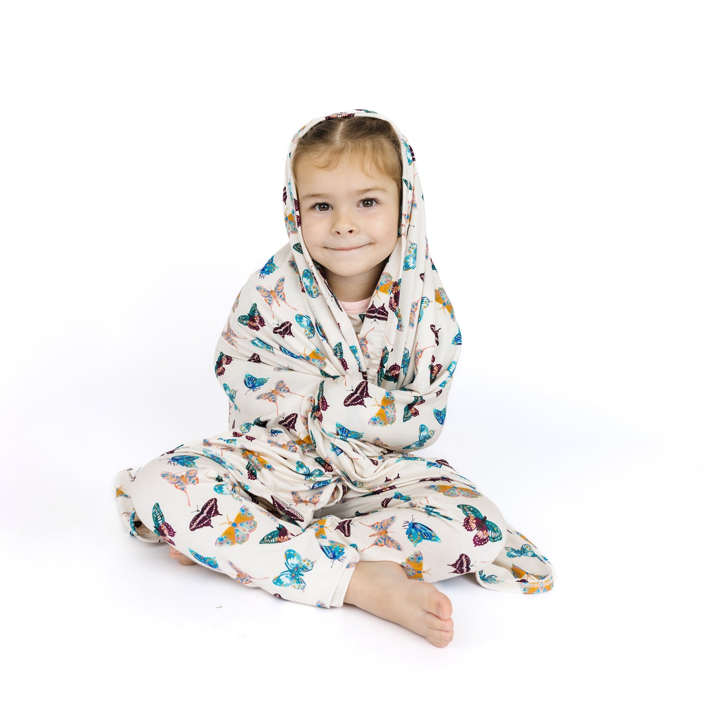 Child wearing a butterfly-patterned onesie on a white background