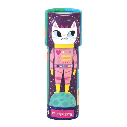 Colorful cylindrical toy packaging with a cat astronaut design on a white background, featuring the brand 'Mudpuppy'.