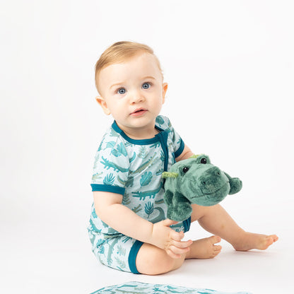 baby boy in his "gator friends" shortie, plays with Andy the Alligator. 