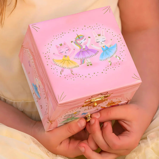a little girl holding a jewelry box that has animal ballerinas on the front and gold hardware