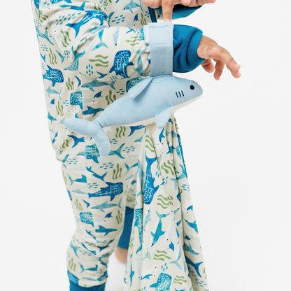 Little boy holding the Shark Friends Lovey on his wrist.
