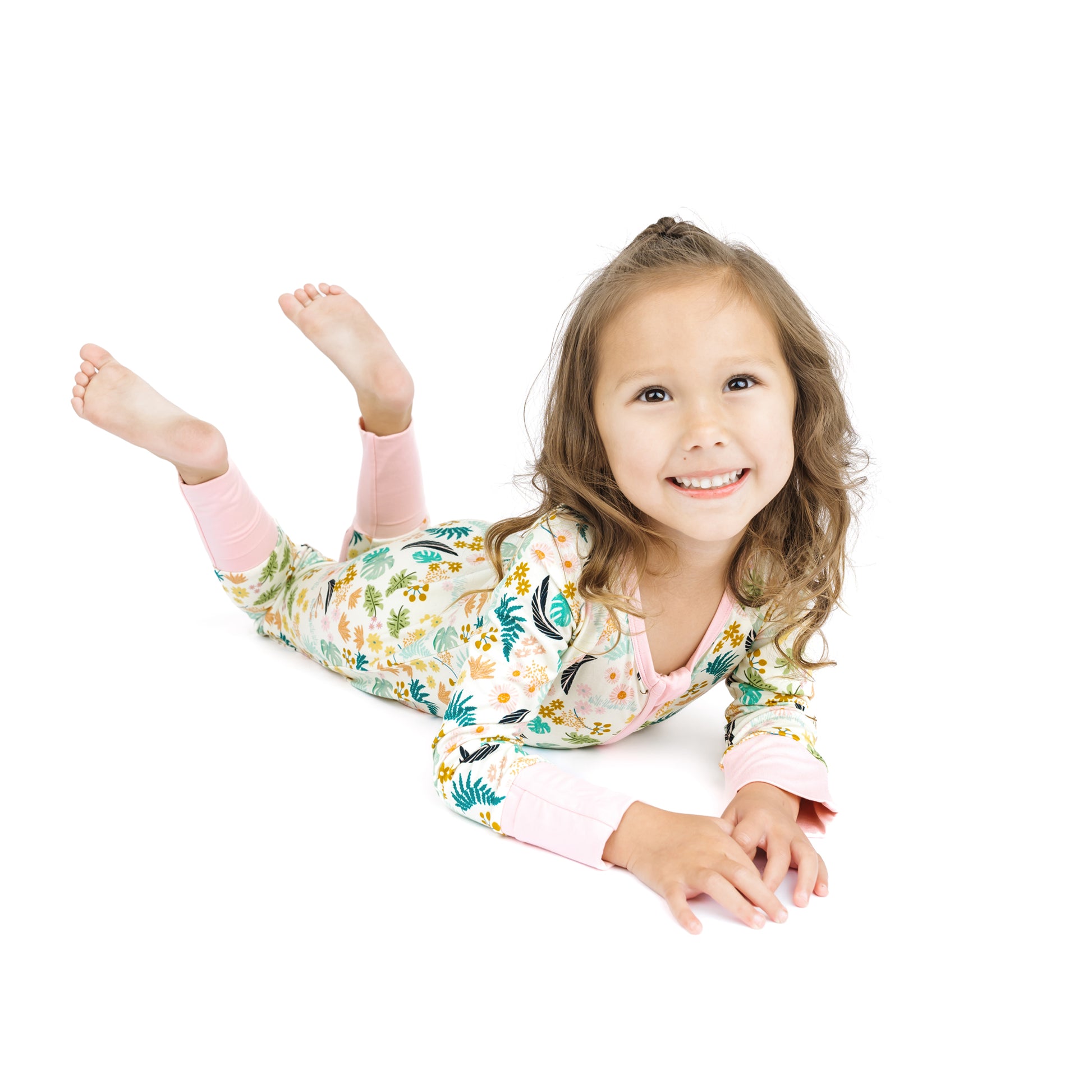 A baby standing while wearing the Tropical Blooms floral bamboo pajamas, showing the stretchy and comfortable fit for playtime.