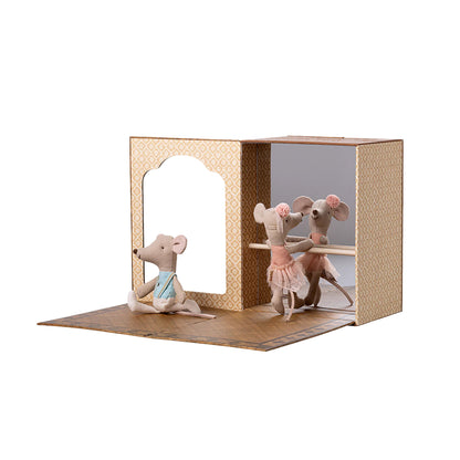 Two toy mice in a cardboard box on a white background