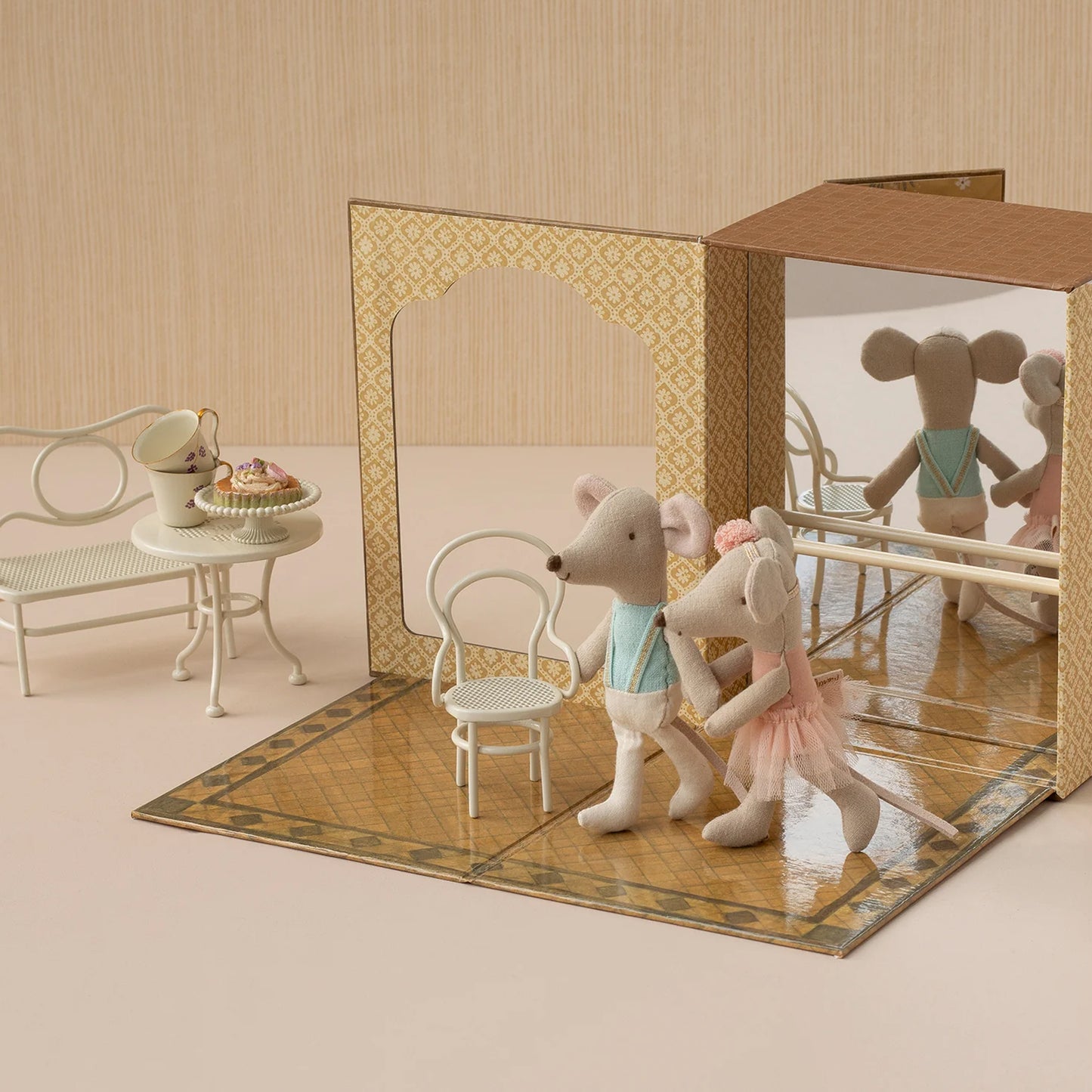 Toy mice in a miniature room with furniture and a mirror.