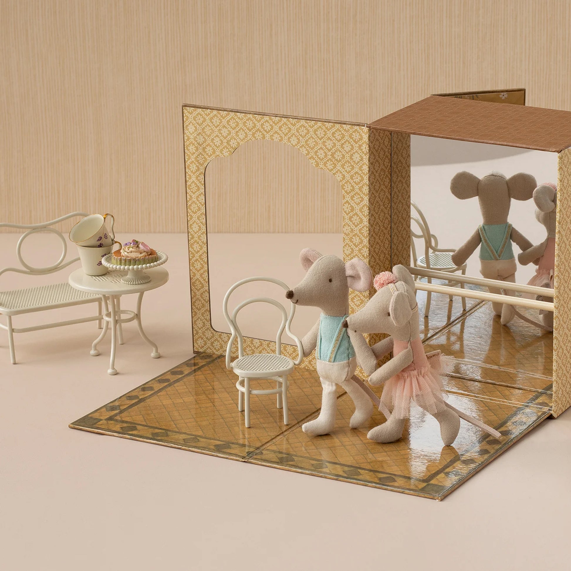 Toy mice in a miniature room with furniture and a mirror.