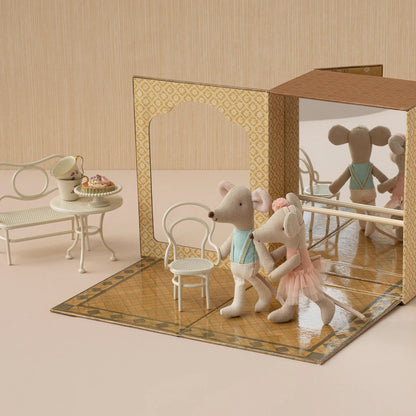 Toy mice in a miniature room with furniture and a mirror.