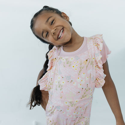 Young girl wearing a pink floral dress against a white background