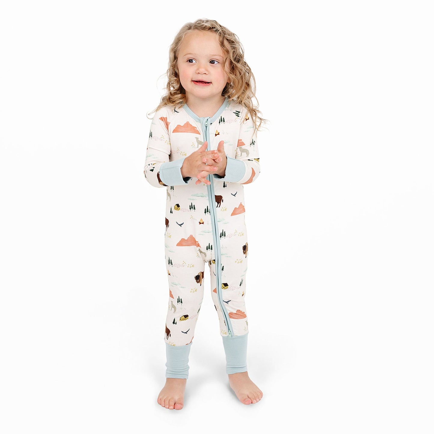 Child wearing a patterned onesie with a white background