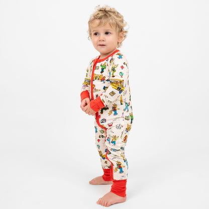 Baby boy wearing our buttery-soft  bamboo convertible pajama featuring red trims and playful illustrations of Arthur™ PBS Character, books, and school bus, a beige background.