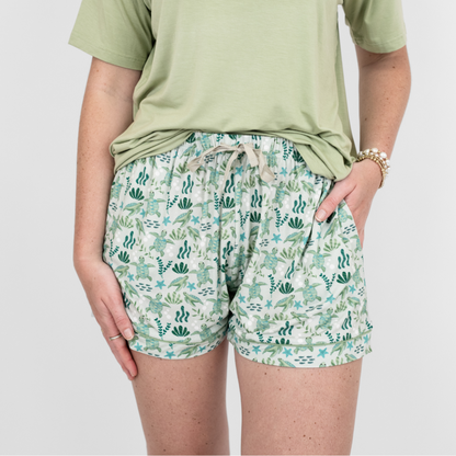 Close up of our Save the Sea Turtles women's bamboo pajama shorts by Emerson and Friends. Featuring a soft sea-green background with hand-drawn turtles, seaweed, and starfish, these eco-friendly shorts are designed for ultimate comfort and sustainability.