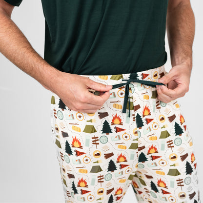 Person wearing shorts with a camping pattern on a plain background