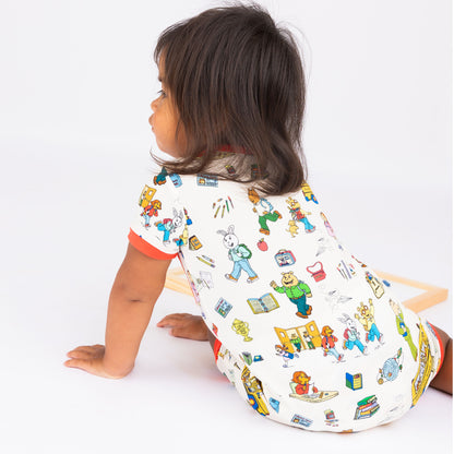 Close up on our soft-buttery bamboo baby shortie romper crafted from buttery-soft bamboo, featuring red trims and playful illustrations of Arthur™ PBS Character, books, and school bus, a beige background.