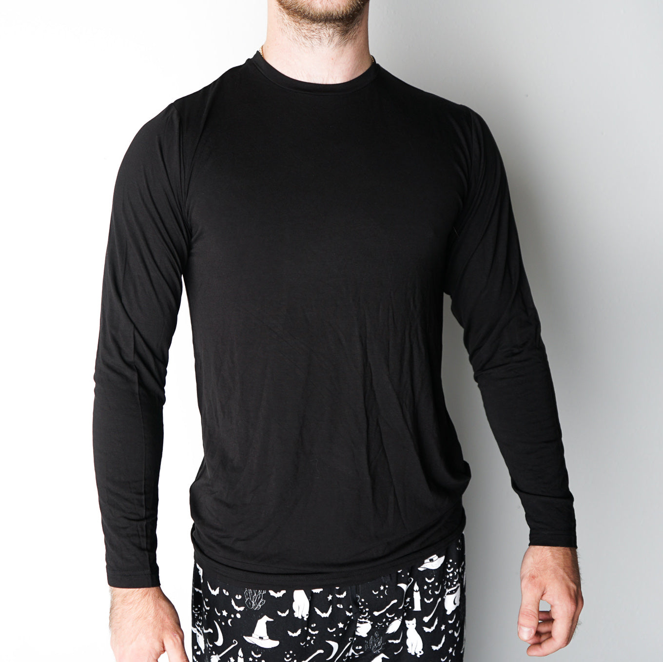 man poses in the black long-sleeved t-shirt. 