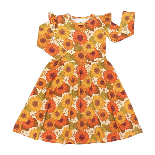 the "sunflower" long-sleeved twirl dress. the "sunflowers" print is a sunflower floral design. it has a variety of yellow, orange, and red sunflowers, mixed into green leaves. 