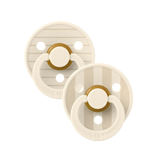 Two beige pacifiers with brown rings on a white background