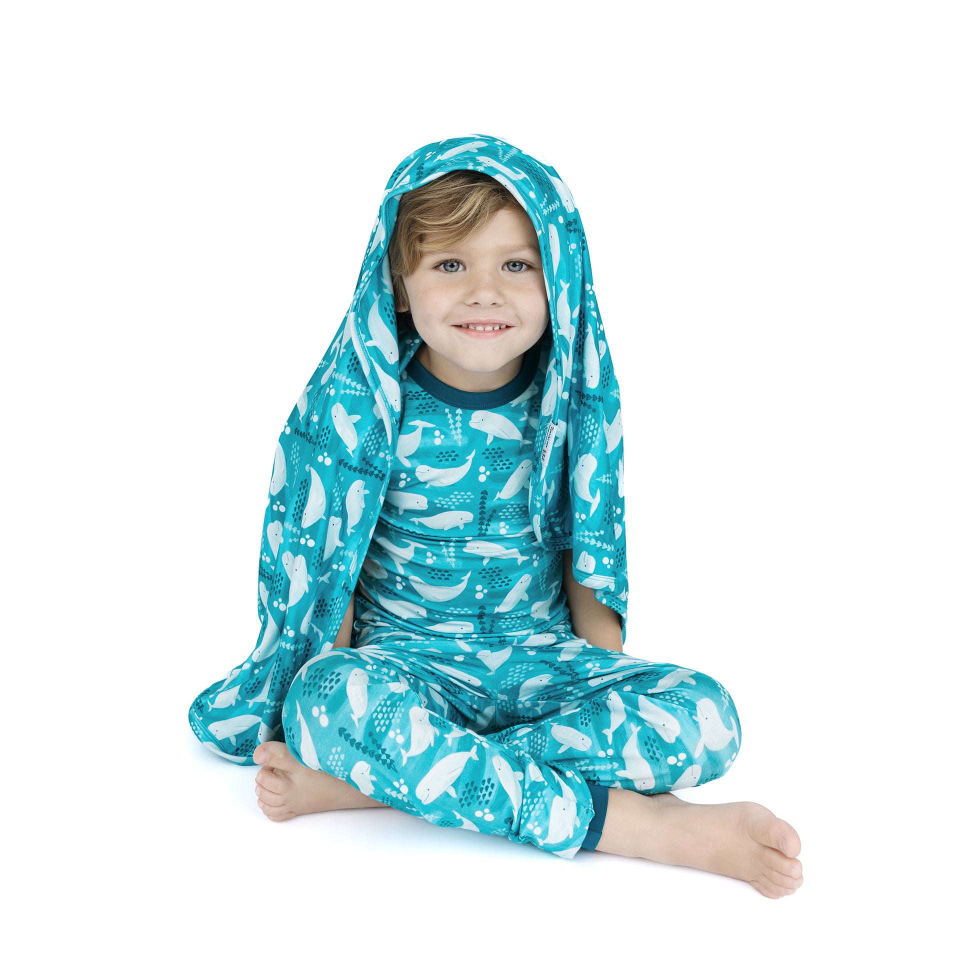 Child wearing a blue and white patterned two piece set pajama with our bamboo blanket