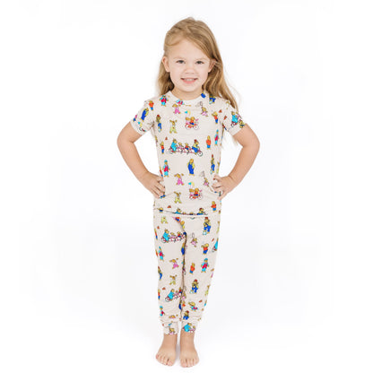 Child wearing a pajama set with a colorful pattern on a white background