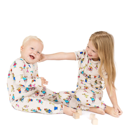 Two children wearing pajamas with a colorful pattern on a white background