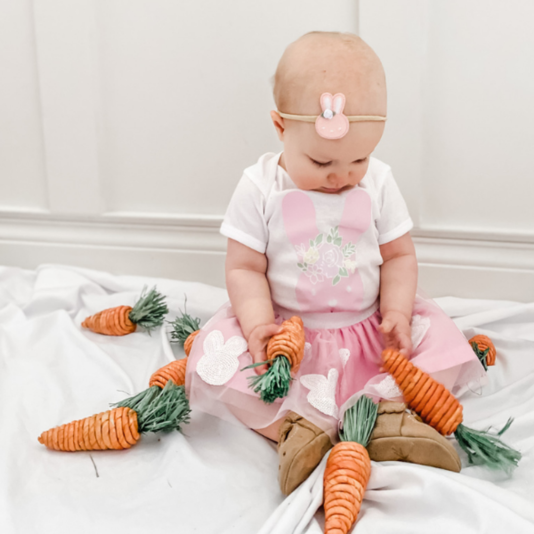 little girl wearing easter headband with a pink glittery easter bunny head on the front