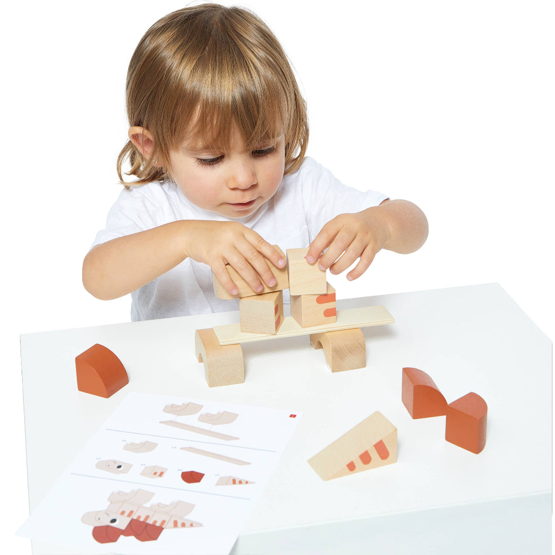 little kid playing with building blocks that go together and make colorful dinosaurs