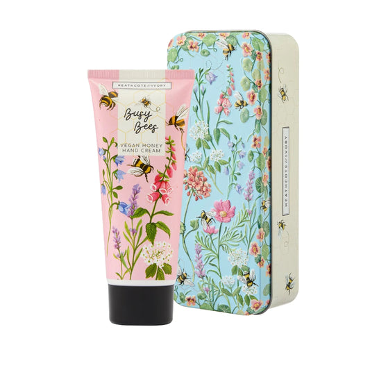 Pink bottle of hand cream with multi-colored bees and flowers and blue tin with multi-colored bees and flowers