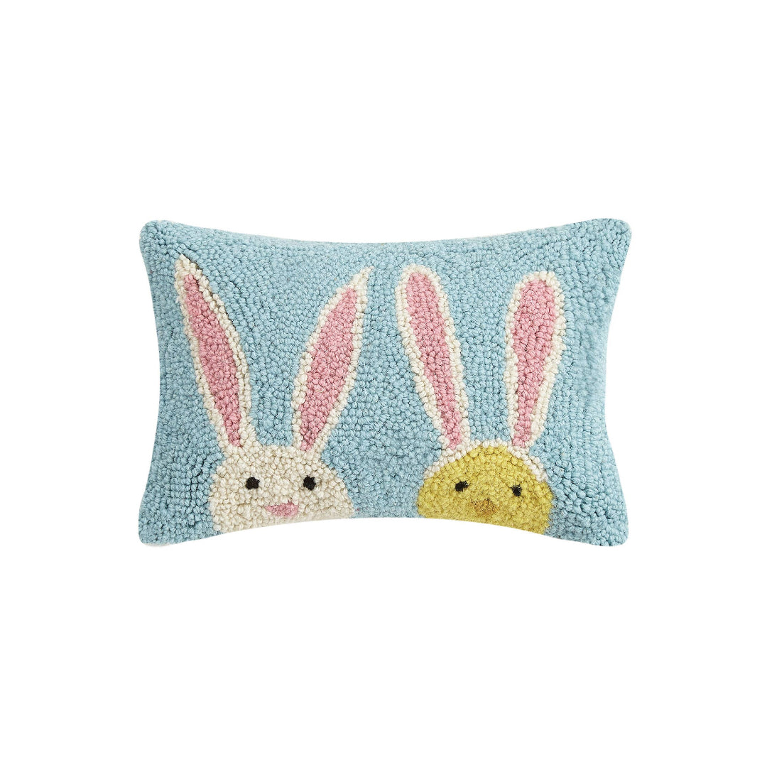 Easter themed pillow thats light blue and has a bunny on the front and a chick wearing bunny ears