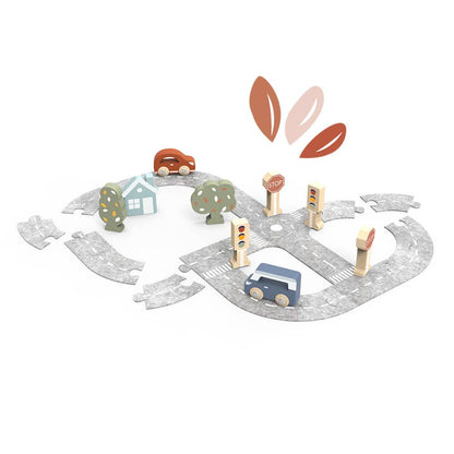 Wooden toy road set with cars, houses, and traffic lights on a white background