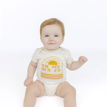 Baby wearing a bodysuit with 'Oh Sun Sunset' design on a white background