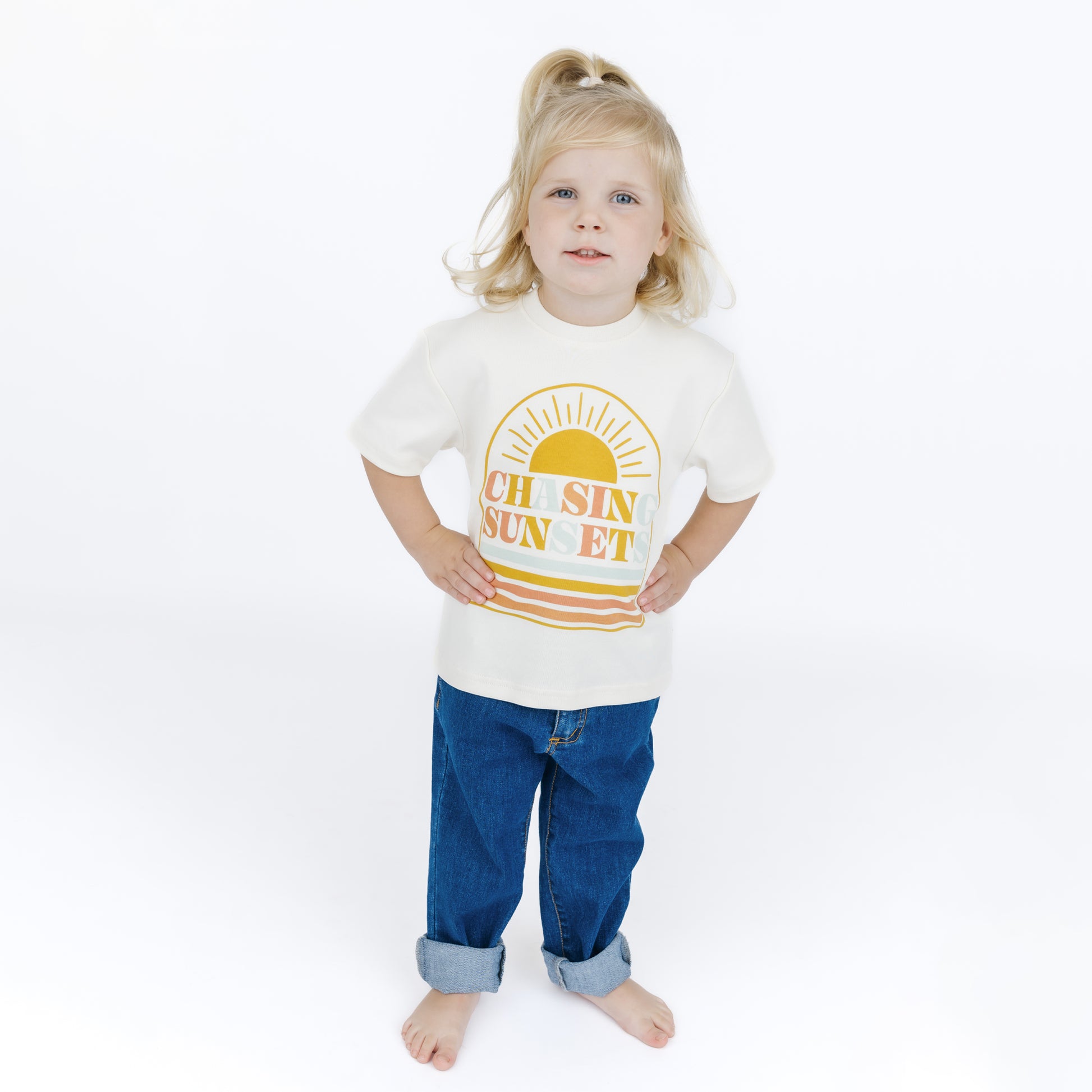 Child wearing a white t-shirt with a sun graphic and text on a white background